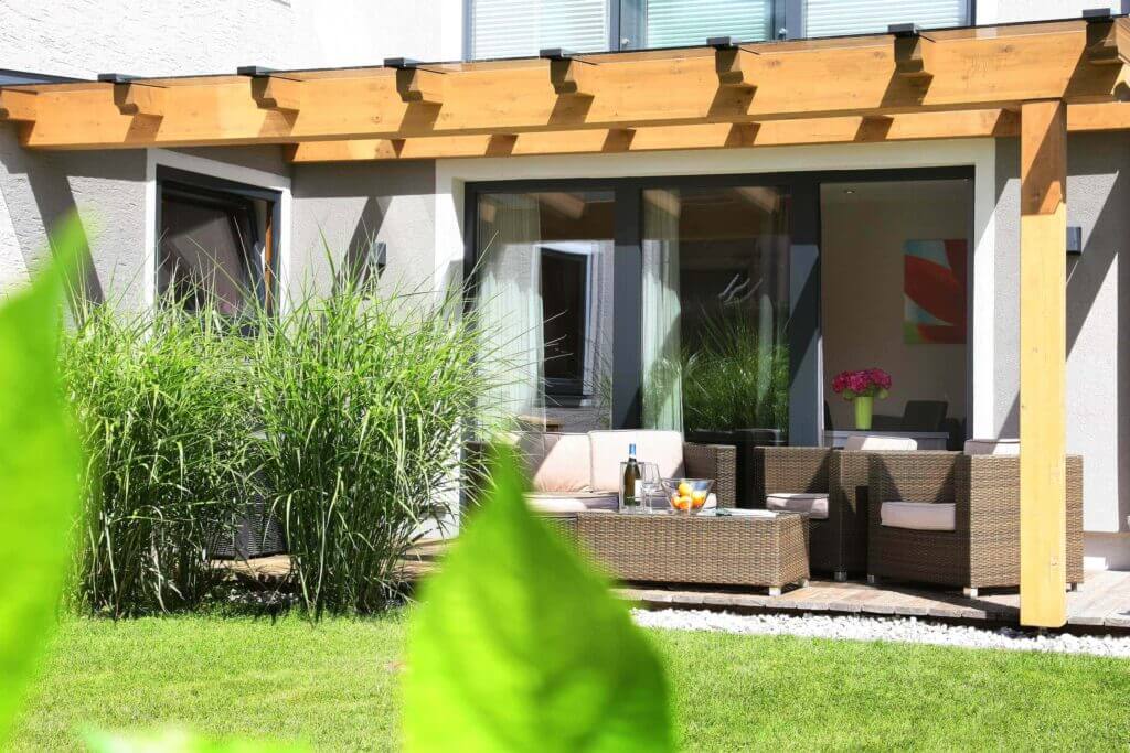 Gemütliche Terrasse mit Sitzgelegenheiten, umgeben von Grün in den Annika Apartments.