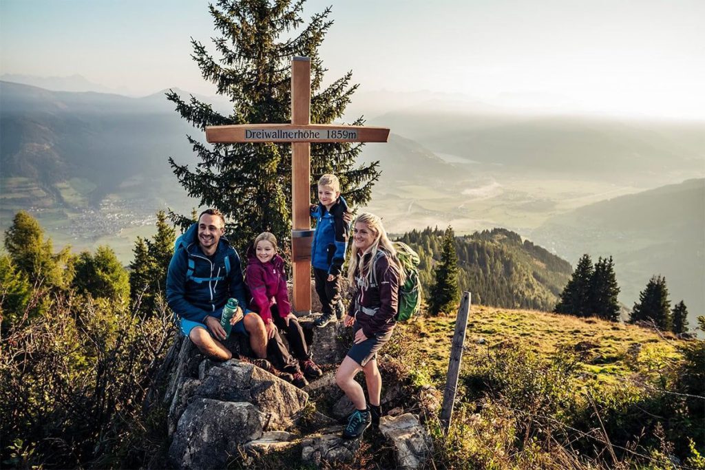 Familie wandert auf der Dreibauerhöhe mit Blick auf Zell am See und die umliegende Natur.