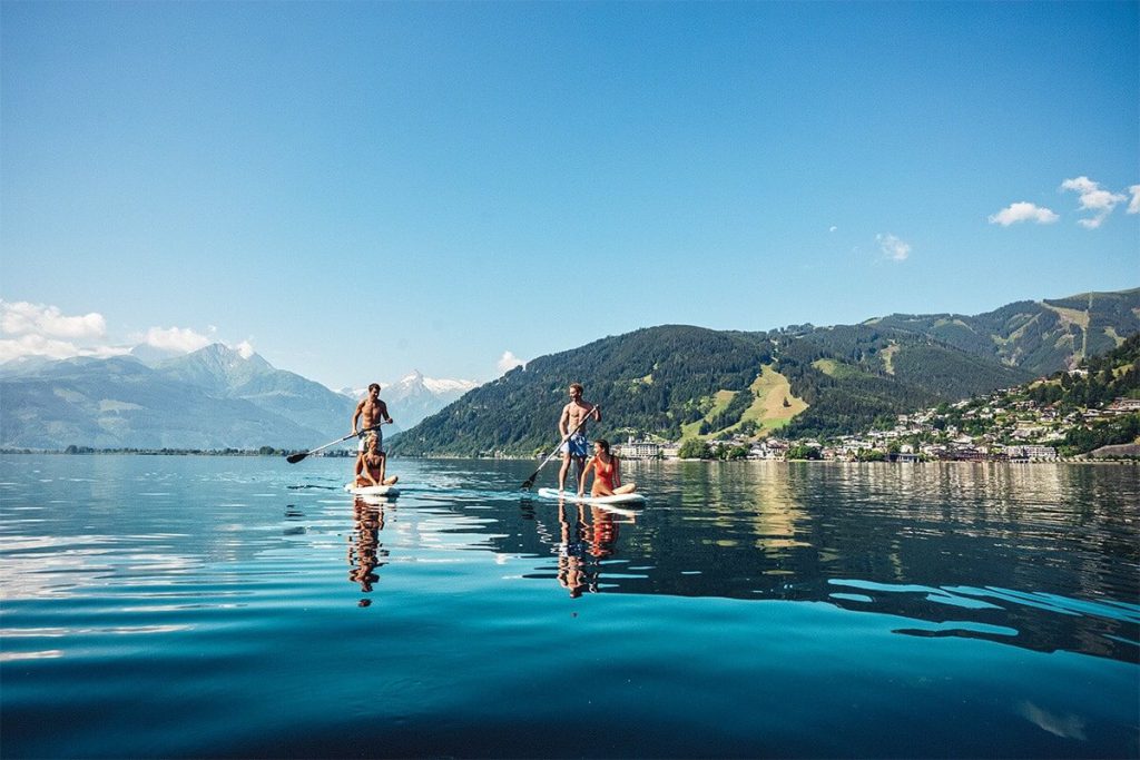 Stand-up-Paddler auf dem Zeller See mit Bergblick und malerischer Umgebung.