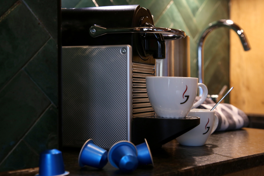 Kávovar Nespresso se dvěma šálky a kapslemi na kuchyňské lince v apartmánu D